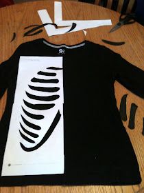 an image of a black and white shirt on top of a wooden table with scissors