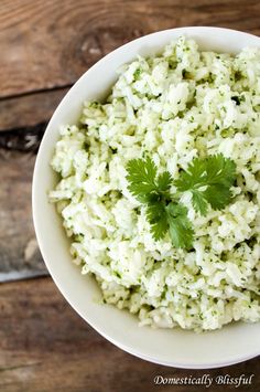 a white bowl filled with rice and cilantro garnished with parsley