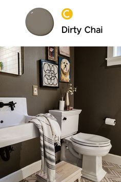 the bathroom is decorated in shades of gray, white and brown with pictures on the wall