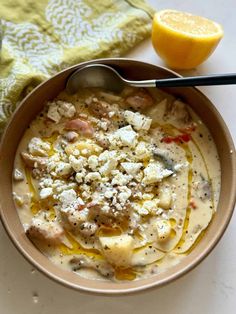 a bowl filled with soup next to an orange slice