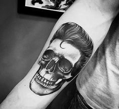 a man with a skull tattoo on his arm