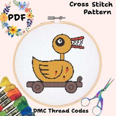 the cross stitch pattern shows a yellow duck on a skateboard, with scissors and thread spools nearby