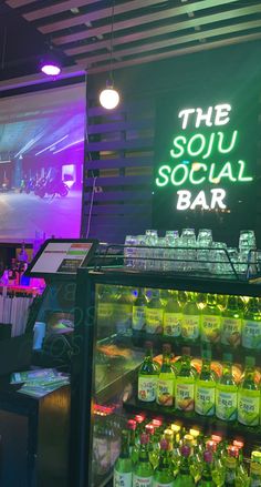 the soul social bar is lit up with neon signs and bottles in front of it