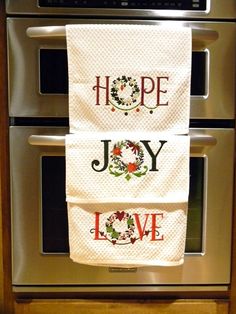 two kitchen towels hanging on the wall above an oven