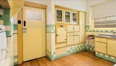 an old fashioned kitchen with yellow cabinets and wood floors