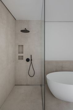 a bathroom with a white bathtub and black shower head