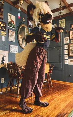 a person in an animal costume standing on a hard wood floor next to a blue wall