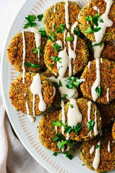 a white plate topped with crab cakes covered in sauce