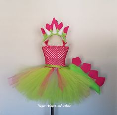 a green and pink tutule dress with white polka dots on the top, sitting on a mannequin