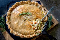 a chicken pot pie on a cutting board with a fork