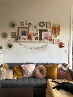 a living room filled with lots of furniture and pictures on the wall above it's couch