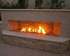 an outdoor fireplace lit up with bright flames