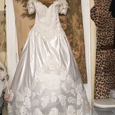 a wedding dress hanging on a wall in a room with leopard prints and other items