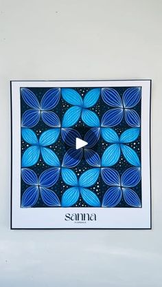 an art piece with blue leaves and the word sanna written in black on it