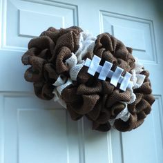 a burlocked wreath with an american football on it hangs on the front door