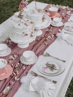 a table topped with lots of white and pink plates