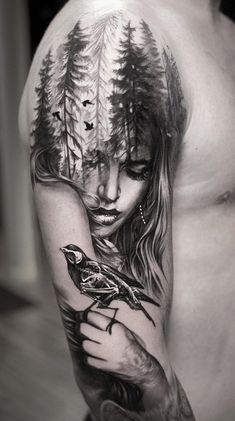 a man with a tattoo on his arm holding a bird in front of her face