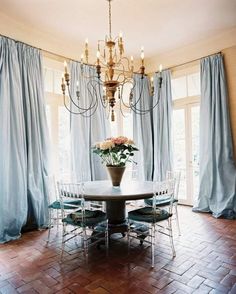 a dining room table with chairs and a chandelier hanging from it's ceiling