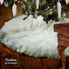 a christmas tree decorated with white feathers and lights is in the corner of a room