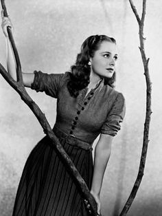 a woman standing next to a tree branch