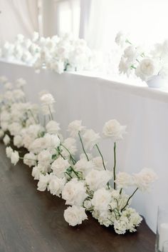 white flowers are lined up on the table