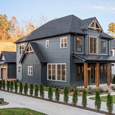 a large gray house with lots of windows on the front and side of it's roof