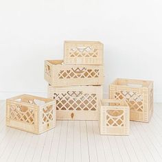 four wooden crates stacked on top of each other in front of a white wall and floor