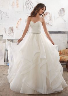 a woman in a white wedding dress posing for the camera