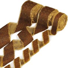 three rolls of brown and gold colored ribbon on white background with clippings attached to each roll