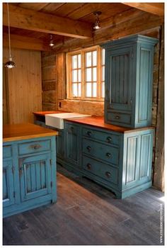 an old fashioned kitchen with blue cabinets and wood flooring is pictured in this image