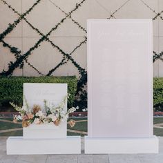 two white pedestals with flowers on them and a sign that says you are married