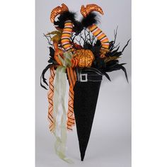 an arrangement of halloween decorations in a black cone with orange and white striped stockings on it