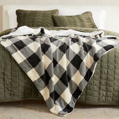 a bed covered in a green and white checkered blanket