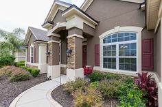 a house that has some plants in front of it and landscaping around the outside area