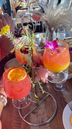 two glasses filled with drinks sitting on top of a table next to plates and utensils