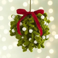 a green christmas ornament hanging from a red ribbon