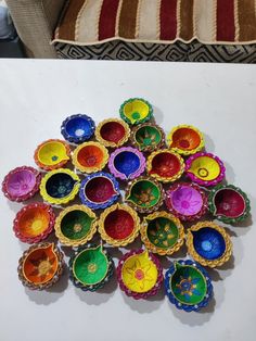 a pile of colorful bowls sitting on top of a white table