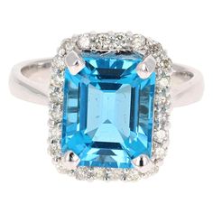 This beautiful Emerald Cut Blue Topaz and Diamond ring has a stunning 5.78 Carat Blue Topaz and its surrounded by 24 Round Cut Diamonds that weigh 0.44 Carats. The total carat weight of the ring is 6.22 Carats. The setting is crafted in 14K White Gold and weighs approximately 5.7 grams. Measurements of the Blue Topaz are 9mm x 11mm. Ring sizing can be done free of charge if needed; the ring is currently a size 7. Topaz Diamond Ring, Expensive Perfume, Gold Cocktail Ring, Blue Sapphire Diamond, Diamond Cocktail Rings, Topaz Stone, Blue Sapphire Rings, Blue Rings, Round Cut Diamond