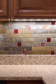 a kitchen counter with brown cabinets and tile backsplash