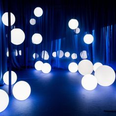 a room with blue curtains and white balls on the floor