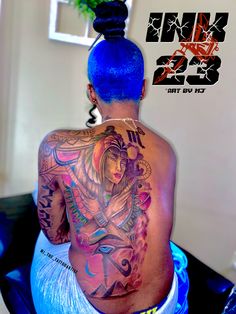 a woman with blue hair and tattoos on her back