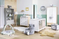 a baby's room is decorated in pastel green, white and grey colors