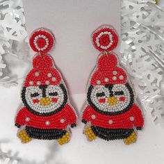 a pair of red and black beaded earrings with an angry bird on the front