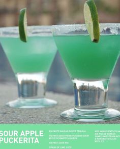 two green drinks with lime wedges in them