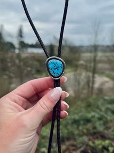 A jaw dropping all natural Kingman Turquoise shadow box bolo with a hand stamped bezel on a black / brown leather cord with sterling silver tips. The bolo measures about 38 inches including the silver tips. This piece is made with genuine stones, sterling and fine silver. Spiritual Turquoise Jewelry With Adjustable Cord, Southwestern Lariat Turquoise Necklace, Southwestern Adjustable Lariat Turquoise Necklace, Southwestern Adjustable Turquoise Lariat Necklace, Adjustable Southwestern Turquoise Lariat Necklace, Adjustable Southwestern Lariat Jewelry, Artisan Lariat Jewelry With Adjustable Cord, Artisan Silver Jewelry With Adjustable Length, Western Style Lariat Jewelry With Adjustable Length