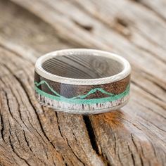 a wooden table with a ring on it that has mountains painted on the inside of it