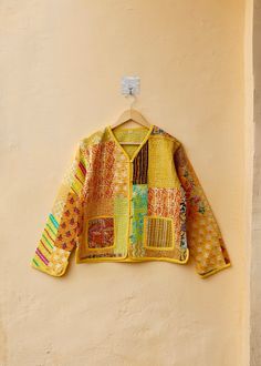 a yellow jacket hanging up against a wall