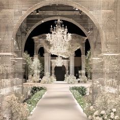 an elaborately decorated walkway with chandelier and flowers