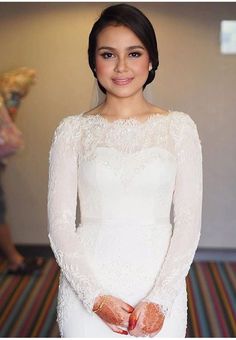 a woman in a white dress is posing for the camera