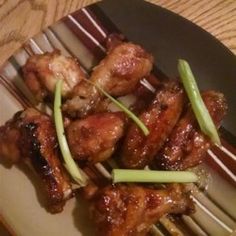 chicken wings with green onions and scallions on a plate